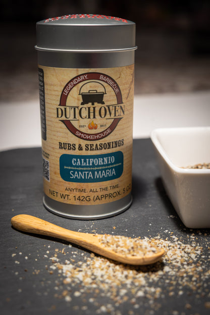 Dutch Oven seasoning canister with a wooden spoon and seasoning on a dark surface